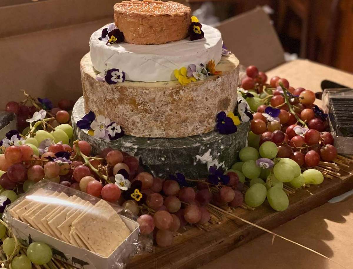 Cheese tower with grapes, crackers and edible flowers