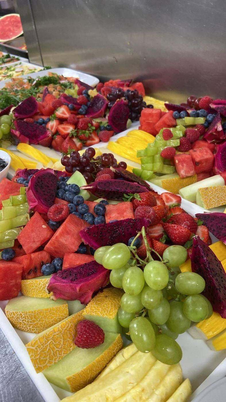 Fresh fruit platter with melon, grapes, strawberries and dragon fruit