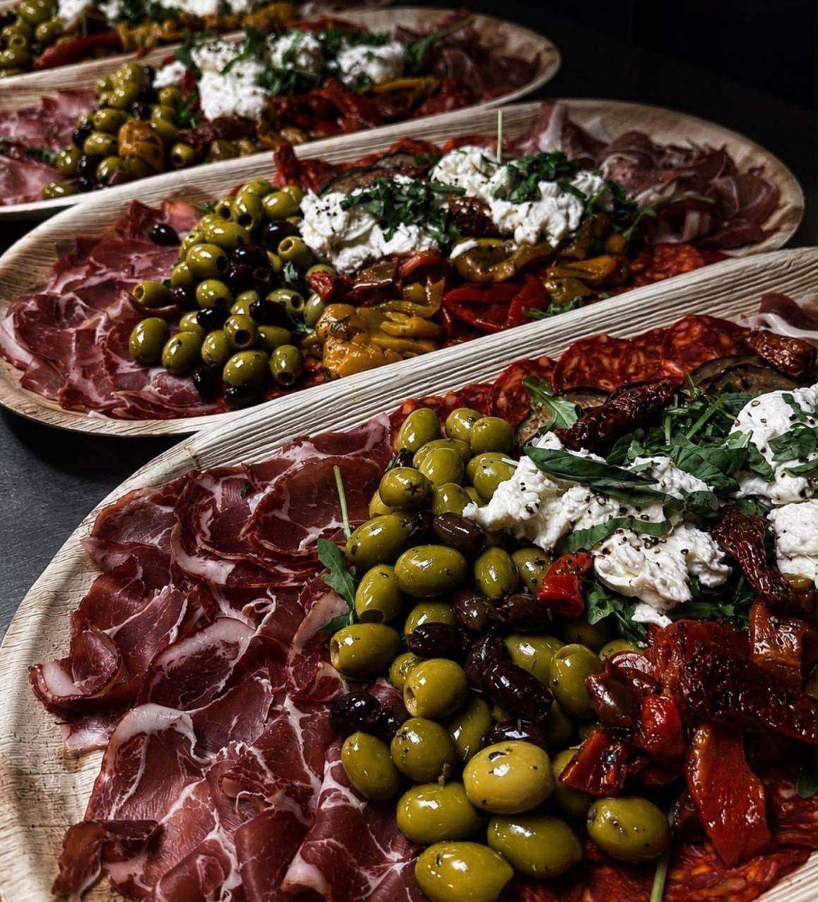 Sharing platters of cured meats, olives, burrata and sun-dried tomatoes