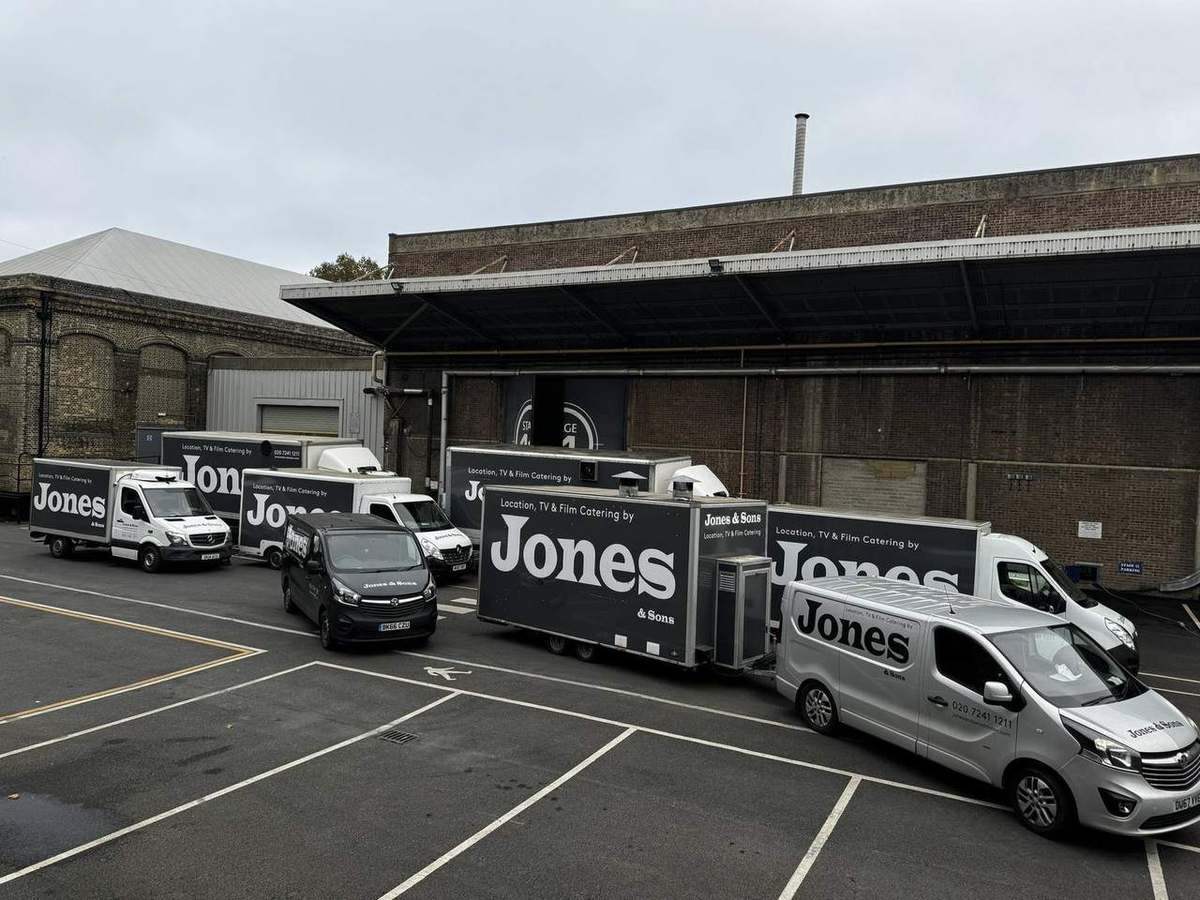 The Jones & Sons catering fleet — trucks and vans lined up at a studio unit base