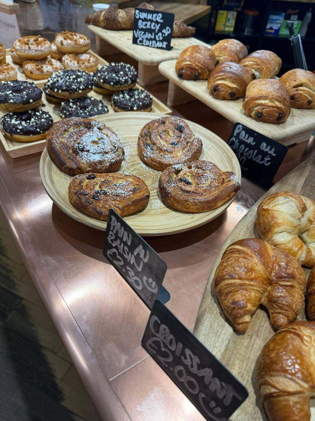 Morning pastries, cinnamon swirls and croissants on the counter