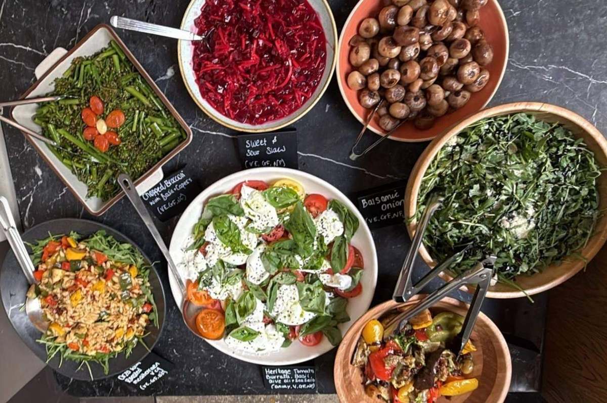 Spread of salad bowls with labelled dishes on a buffet table