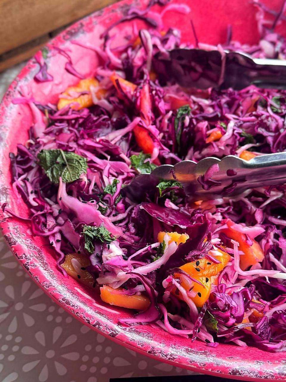 Bowl of red cabbage slaw being served